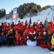 Gruppenfoto mit den Sportlern, Trainern und dem Maskottchen (Snowi)